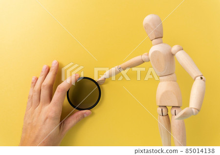 Polarizing filter in the hands of a wooden dummy with space for copying text. Accessory for the photographer Polarizing filter in the hands of a wooden dummy with space for copying text. Accessory for the photographer 85014138