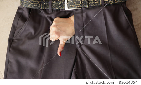 Woman show thumbs down gesture through mans pants Woman show thumbs down gesture through mans pants 85014354