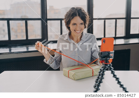 Positive italian woman blogger recording video blog about christmas gift at home Positive italian woman blogger recording video blog about christmas gift at home 85014427