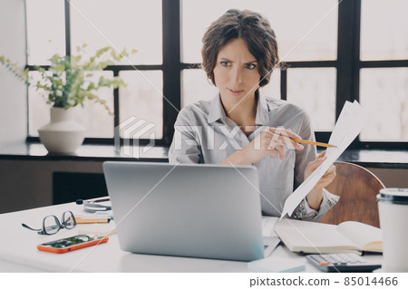 Serious focused Italian businesswoman making video call on laptop in office Serious focused Italian businesswoman making video call on laptop in office 85014466