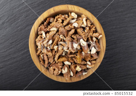 Walnut in wooden bowl on black background with copy space. Walnut in wooden bowl on black background with copy space. 85015532