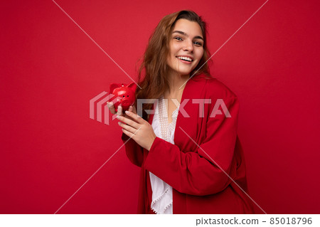 Portrait of positive cheerful fashionable woman in formalwear holding small money box looking like Portrait of positive cheerful fashionable woman in formalwear holding small money box looking like 85018796