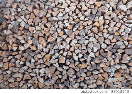 Natural wooden background - closeup of chopped firewood. Firewood stacked and prepared for winter Natural wooden background - closeup of chopped firewood. Firewood stacked and prepared for winter 85018949