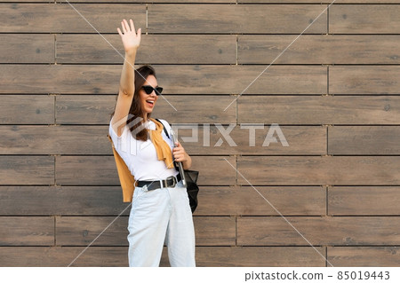 Photo of fascinating beautiful smiling charming young brunette girl wearing stylish clothes holding Photo of fascinating beautiful smiling charming young brunette girl wearing stylish clothes holding 85019443