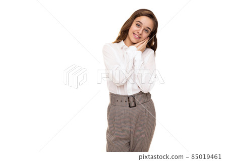 Photo of a beautiful and cute brunette girl with long hair in a white blouse and pants in a cage who Photo of a beautiful and cute brunette girl with long hair in a white blouse and pants in a cage who 85019461