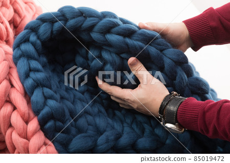 men's hands touching a coarse-knit blanket made of natural wool men's hands touching a coarse-knit blanket made of natural wool 85019472