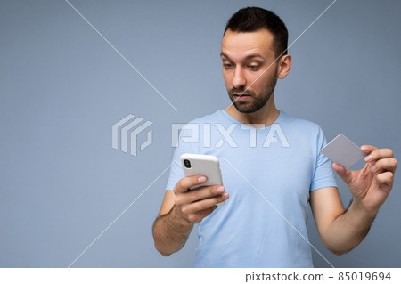 Handsome brunet man wearing everyday clothes isolated on blue background wall with copy space 85019694