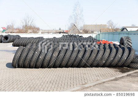 Photo of black big tires on wheels for large cars that lie on gray asphalt on the street 85019698