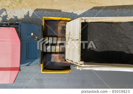 Aerial view of new road construction with asphalt laying machinery at work. Aerial view of new road construction with asphalt laying machinery at work. 85019823
