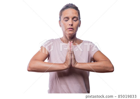 An adult woman standing meditating in prayer pose 85019833