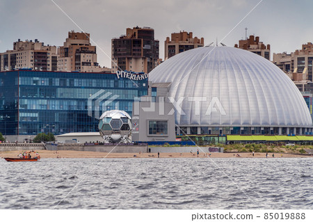 Russia. Saint-Petersburg. June 24, 2021. View in cloudy weather of the Piterland shopping center and the studio of the MATCH TV channel from the Gulf of Finland. Russia. Saint-Petersburg. June 24, 2021. View in cloudy weather of the Piterland shopping center and the studio of the MATCH TV channel from the Gulf of Finland. 85019888