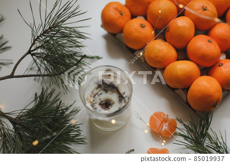 Christmas background with fir tree branches and tangerines. Merry Christmas and Happy New Year Greeting Card Christmas background with fir tree branches and tangerines. Merry Christmas and Happy New Year Greeting Card 85019937