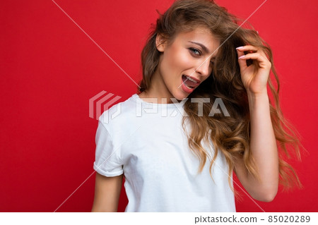 Young beautiful curly blonde woman with sexy expression, cheerful and happy face wearing casual Young beautiful curly blonde woman with sexy expression, cheerful and happy face wearing casual 85020289