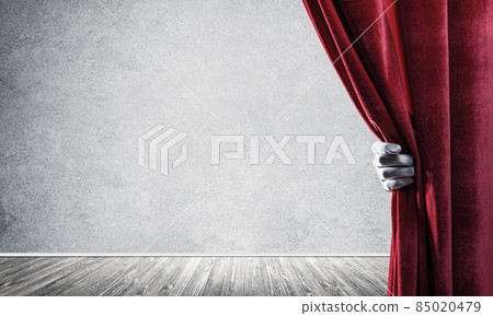 Concrete wall behind drapery curtain and hand opening it Concrete wall behind drapery curtain and hand opening it 85020479