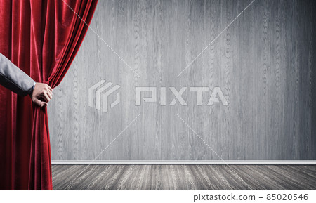 Concrete wall behind drapery curtain and hand opening it Concrete wall behind drapery curtain and hand opening it 85020546