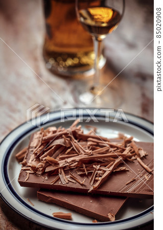 A glass of cognac, brandy or whiskey and grated pieces of chocolate bar 85020908