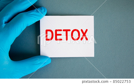 Hand in blue glove with white card. Concept word detox. Hand in blue glove with white card. Concept word detox. 85022753