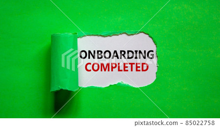 Onboarding completed symbol. Words 'Onboarding completed' appearing behind torn green paper. Beautiful green background. Business, onboarding completed concept, copy space. 85022758