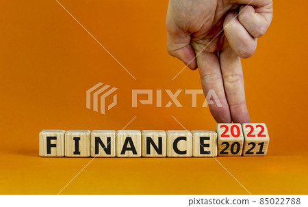 2022 finance and new year symbol. Businessman turns wooden cubes, changes words 'finance 2021' to 'finance 2022'. Beautiful orange background, copy space. Business, 2022 finance and new year concept. 2022 finance and new year symbol. Businessman turns wooden cubes, changes words 'finance 2021' to 'finance 2022'. Beautiful orange background, copy space. Business, 2022 finance and new year concept. 85022788