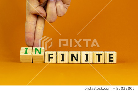 Finite or infinite symbol. Businessman turns wooden cubes and changes the word 'finite' to 'infinite'. Beautiful orange table, orange background. Business, finite or infinite concept. Copy space. Finite or infinite symbol. Businessman turns wooden cubes and changes the word 'finite' to 'infinite'. Beautiful orange table, orange background. Business, finite or infinite concept. Copy space. 85022805