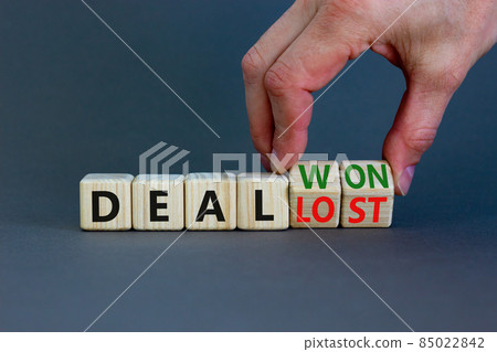Deal lost or won symbol. Businessman turns wooden cubes and changes words 'deal lost' to 'deal won'. Beautiful grey background, copy space. Business and deal lost or won concept. Deal lost or won symbol. Businessman turns wooden cubes and changes words 'deal lost' to 'deal won'. Beautiful grey background, copy space. Business and deal lost or won concept. 85022842