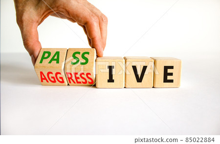 Passive or aggressive symbol. Businessman turns wooden cubes and changes the word passive to aggressive. Beautiful white background, copy space. Business, psychological passive aggressive concept. Passive or aggressive symbol. Businessman turns wooden cubes and changes the word passive to aggressive. Beautiful white background, copy space. Business, psychological passive aggressive concept. 85022884