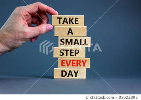 Take a small step every day symbol. Wooden blocks with words Take a small step every day. Beautiful grey background, copy space. Businessman hand. Business, step every day concept. 85022898