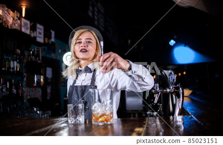 Girl barman creates a cocktail behind the bar Girl barman creates a cocktail behind the bar 85023151