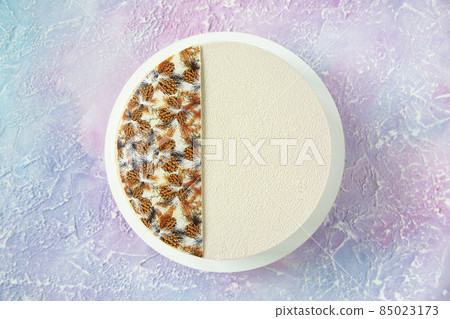 Winter Christmas cake in white with decor on top and copy space - a beautiful view from above on the table with a dessert of white chocolate and velour with frosty streaks Winter Christmas cake in white with decor on top and copy space - a beautiful view from above on the table with a dessert of white chocolate and velour with frosty streaks 85023173