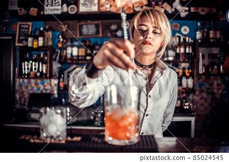 Girl bartender mixes a cocktail in the taproom 85024545