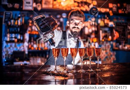 Focused barman mixes a cocktail in cocktail bars 85024573