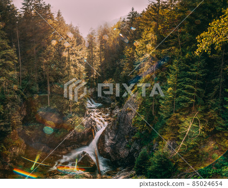 Tatra National Park, Poland. Waterfall Wodogrzmoty Mickiewicza In Summer Mountains Sunset Landscape. Sunlight Through Trees In Tatras. European Nature. UNESCO Tatra National Park, Poland. Waterfall Wodogrzmoty Mickiewicza In Summer Mountains Sunset Landscape. Sunlight Through Trees In Tatras. European Nature. UNESCO 85024654