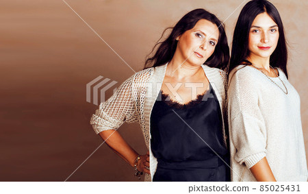 cute pretty teen daughter with mature mother hugging, fashion style brunette makeup close up tann s together, warm colors cute pretty teen daughter with mature mother hugging, fashion style brunette makeup close up tann s together, warm colors 85025431