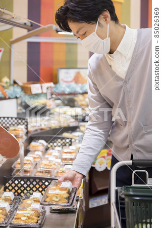 A man in a mask shopping at a supermarket A man in a mask shopping at a supermarket 85026369