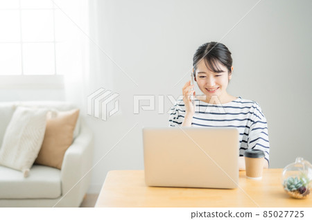 Female teleworking at home (phone with smartphone) Female teleworking at home (phone with smartphone) 85027725