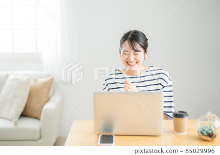 A woman who bursts into laughter at a computer A woman who bursts into laughter at a computer 85029996