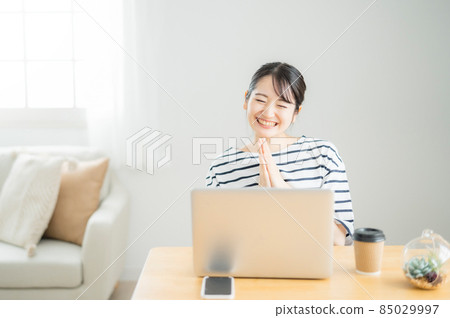 A woman who bursts into laughter at a computer A woman who bursts into laughter at a computer 85029997