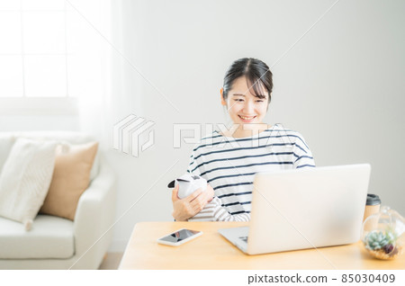 使用計算機的婦女,當抱著嬰孩時 使用計算機的婦女,當抱著嬰孩時 85030409
