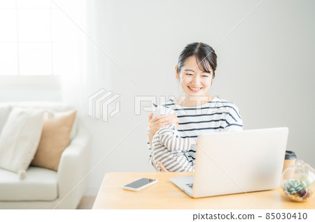 使用計算機的婦女,當抱著嬰孩時 使用計算機的婦女,當抱著嬰孩時 85030410