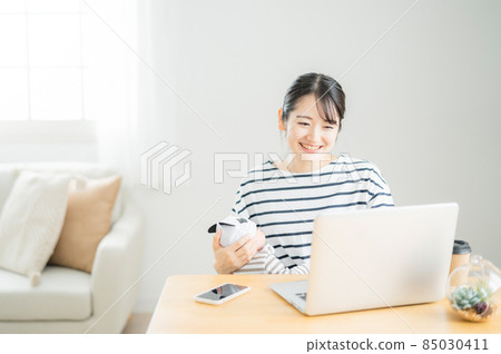 使用計算機的婦女,當抱著嬰孩時 使用計算機的婦女,當抱著嬰孩時 85030411