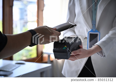 Customer using smart phone scanning for contactless payment. Customer using smart phone scanning for contactless payment. 85031312