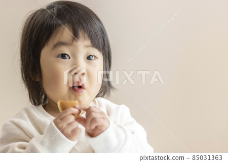 Baby eating small bread by himself (1 year and 5 months old, girl, Japanese) 85031363