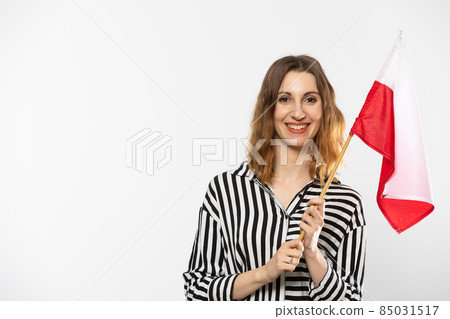 Young girl with a flag of Poland. The student holds the national flag in her hand, the symbol of the Polish state. Woman with flag on white background. Isolated from the background. 85031517