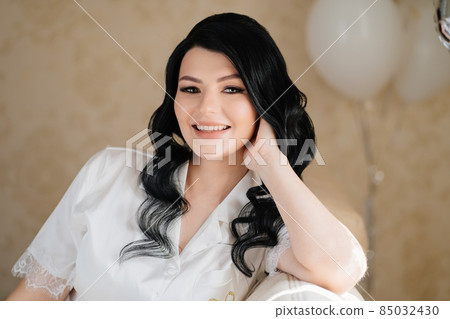 portrait of the brunette bride in a room on the couch. portrait of the brunette bride in a room on the couch. 85032430