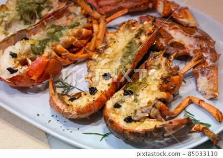 Grilled Lobster with Truffle Sauce served on a white plate. 85033110