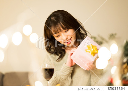 一個女人試圖打開禮物 85035864