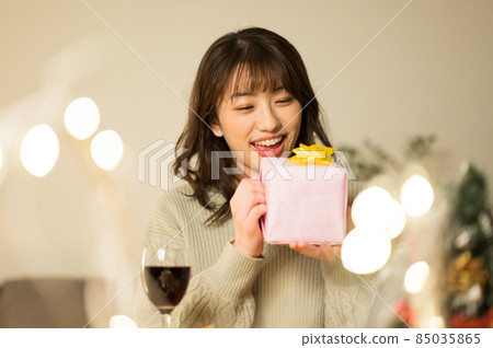 一個女人試圖打開禮物 85035865