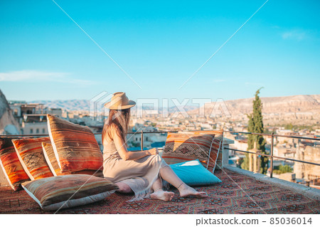 Happy young woman during sunrise watching hot air balloons in Cappadocia, Turkey 85036014