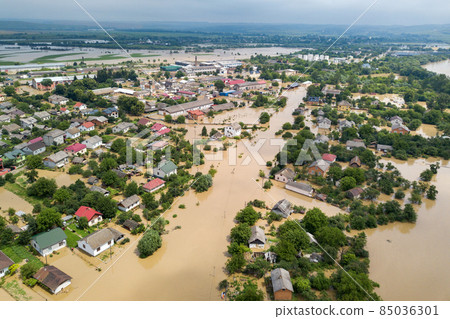 Aerial view of flooded houses with dirty water of Dnister river in Halych town, western Ukraine. Aerial view of flooded houses with dirty water of Dnister river in Halych town, western Ukraine. 85036301