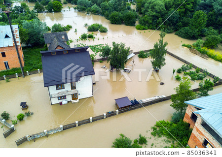 Aerial view of flooded house with dirty water all around it. Aerial view of flooded house with dirty water all around it. 85036341